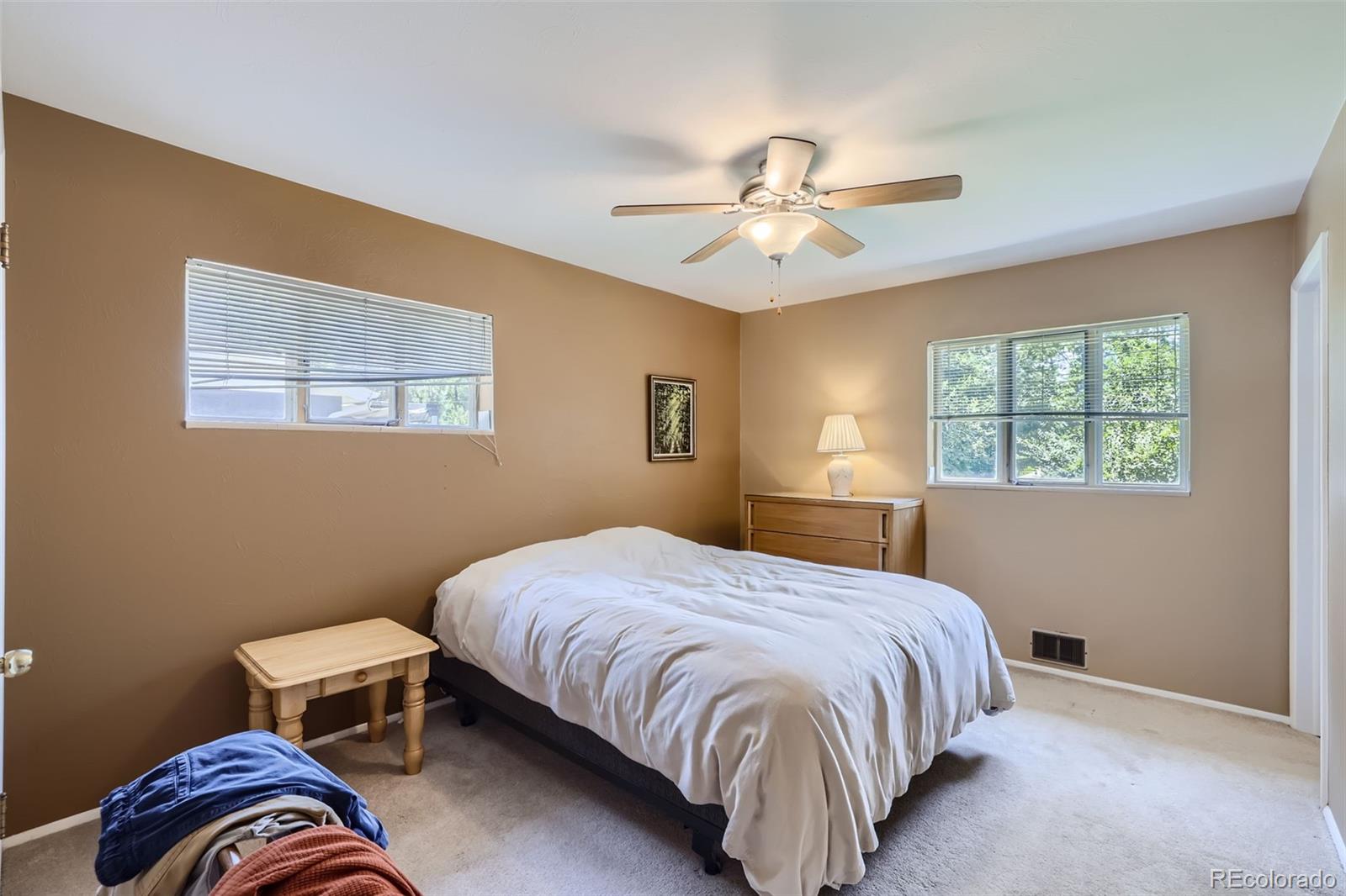 6290 Janice Way Arvada, CO 80004 - Photo 13 of 28 a bedroom with a bed and a chandelier