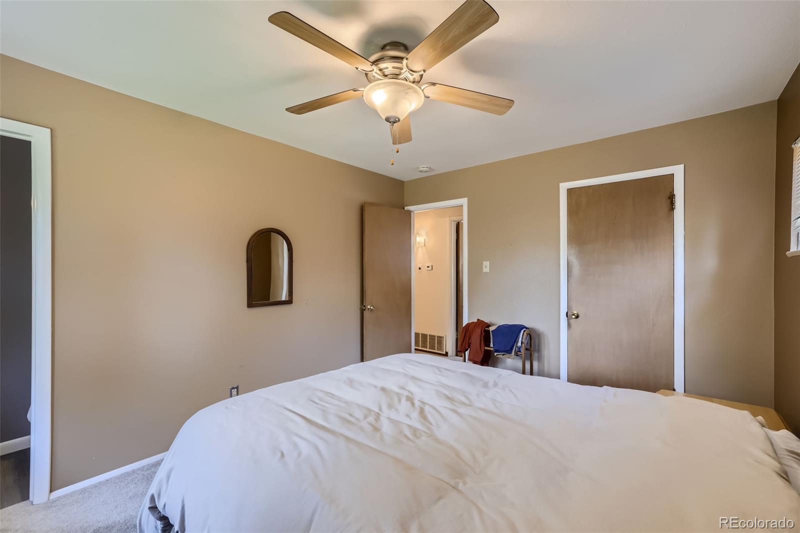 6290 Janice Way Arvada, CO 80004 - Photo 14 of 28 a bedroom with a bed and a chandelier