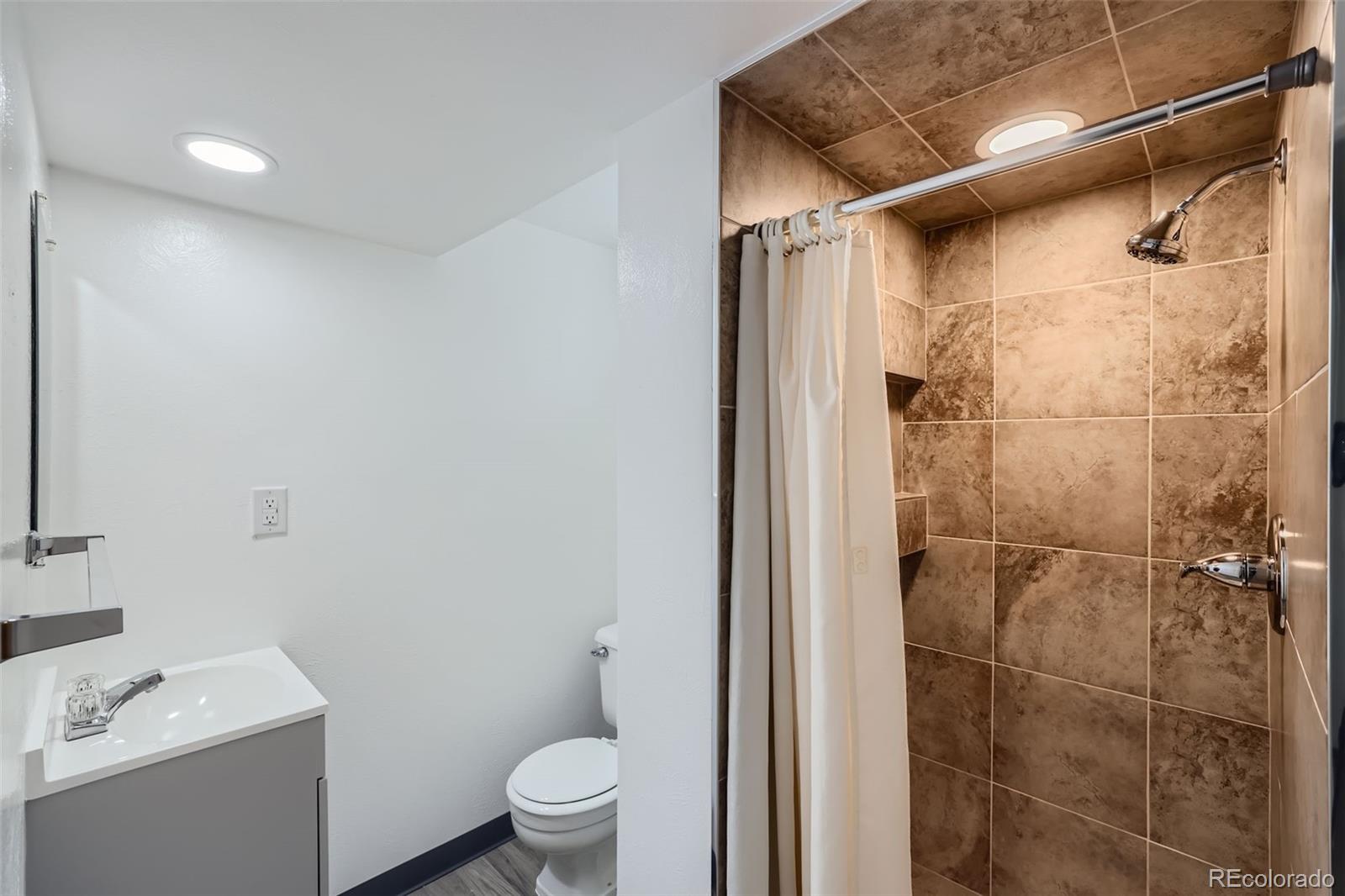 6290 Janice Way Arvada, CO 80004 - Photo 23 of 28 a bathroom with a sink toilet and shower