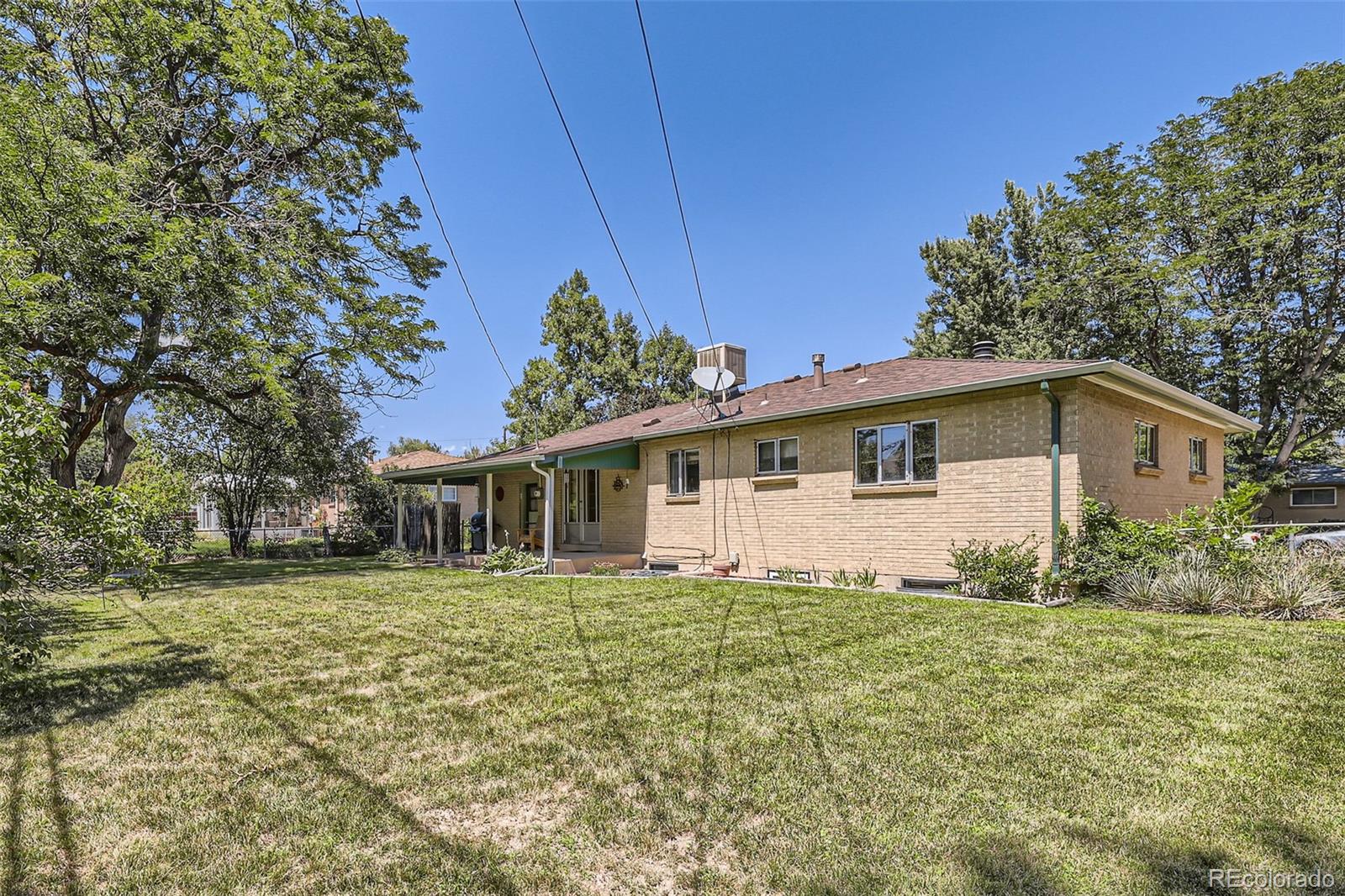 6290 Janice Way Arvada, CO 80004 - Photo 28 of 28 a white house that has a small yard and trees in front of it