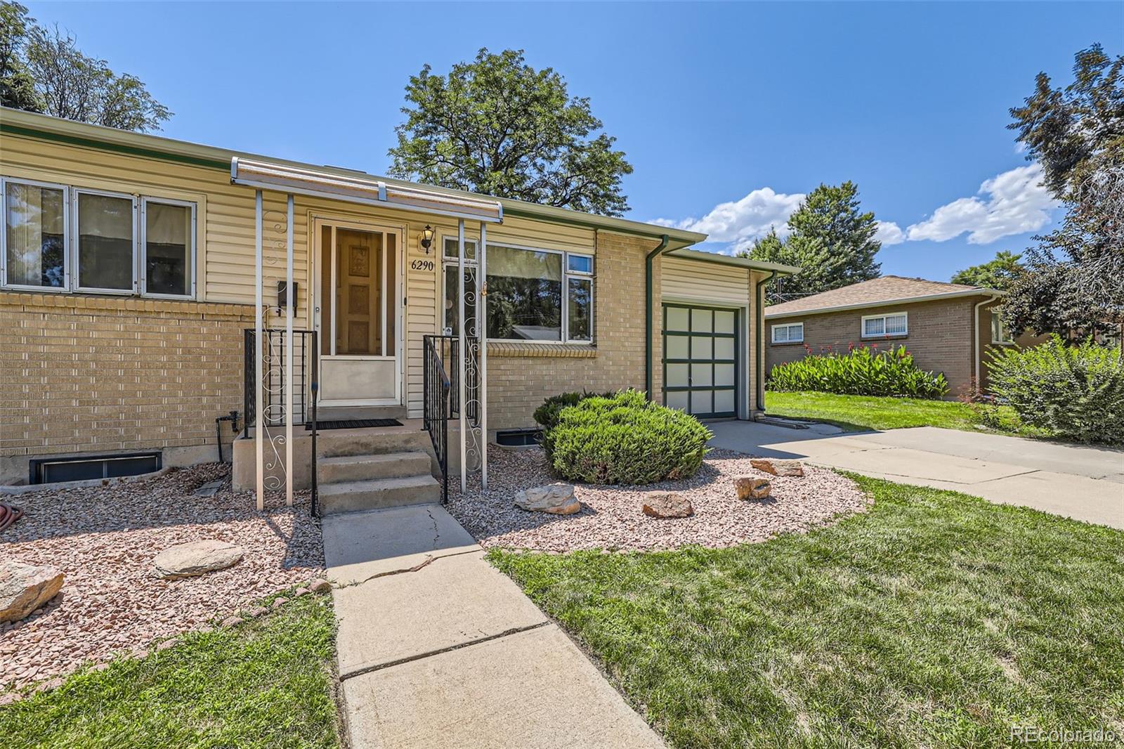 6290 Janice Way Arvada, CO 80004 - Photo 3 of 28 a front view of a house with a yard and porch