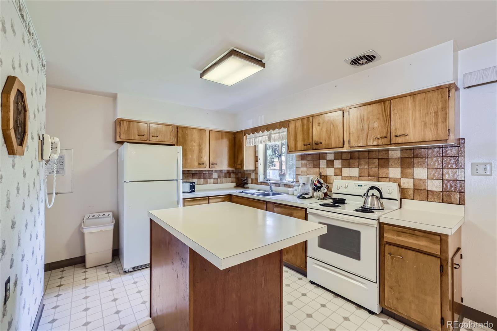 6290 Janice Way Arvada, CO 80004 - Photo 8 of 28 a kitchen with a sink a refrigerator and cabinets