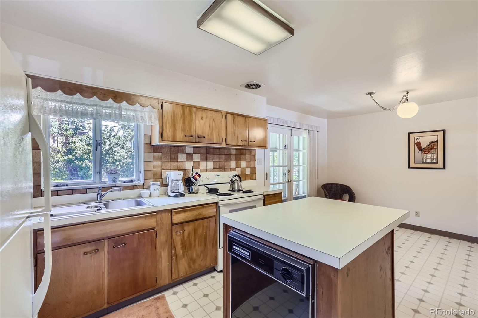 6290 Janice Way Arvada, CO 80004 - Photo 9 of 28 a kitchen with a sink a stove and cabinets