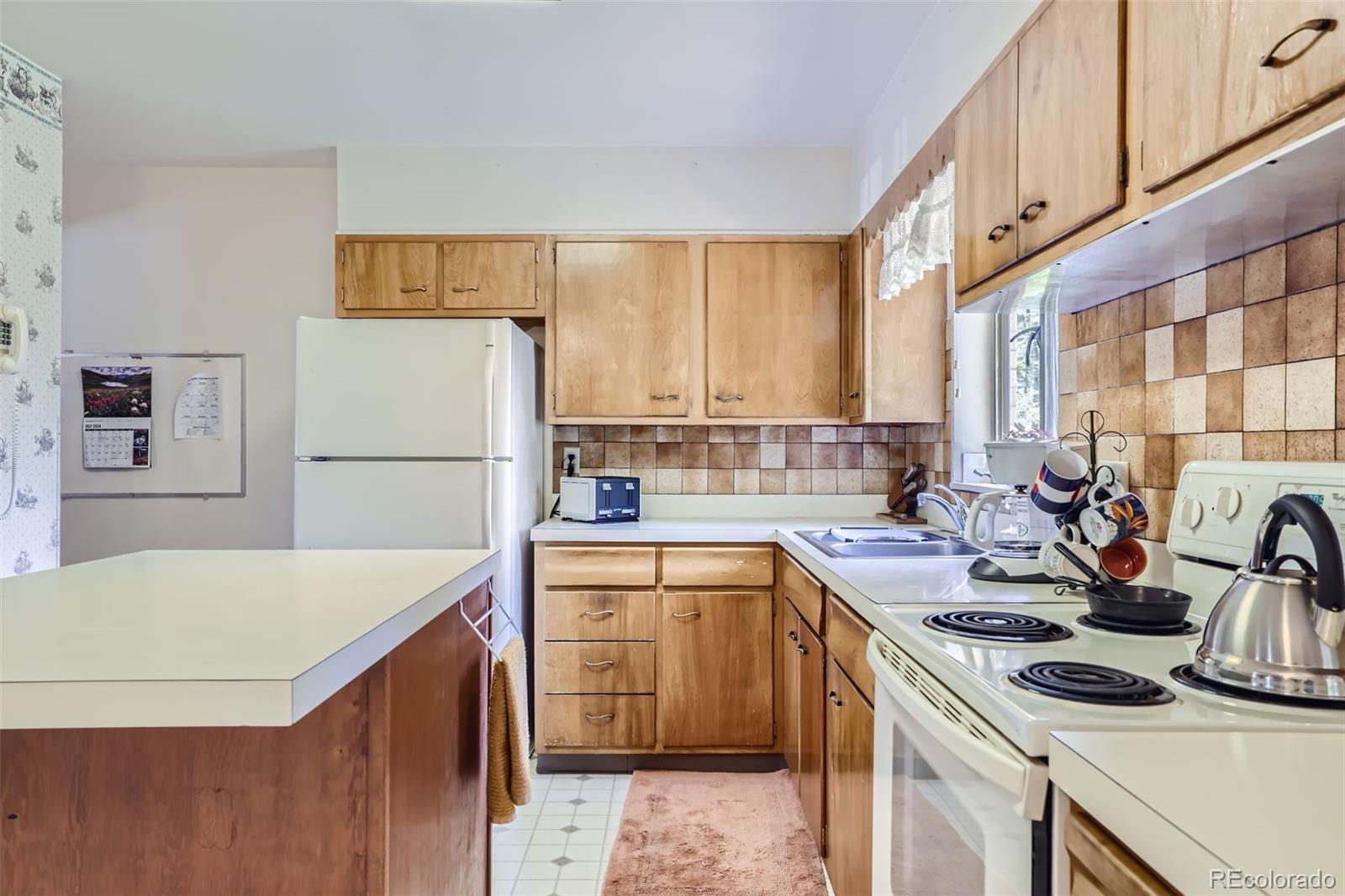 6290 Janice Way Arvada, CO 80004 - Photo 10 of 28 a kitchen with a stove a sink and a refrigerator