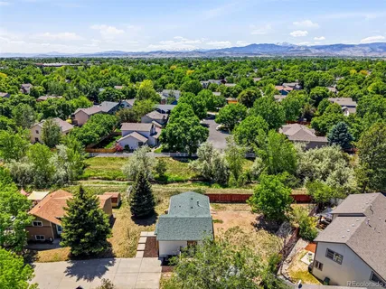 an aerial view of a house with a garden and mountain view in back