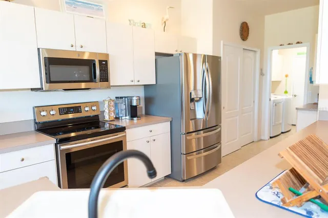 a kitchen with stainless steel appliances a refrigerator a stove a microwave and cabinets