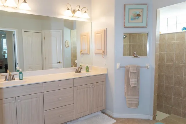 a bathroom with a double vanity sink a mirror and a shower