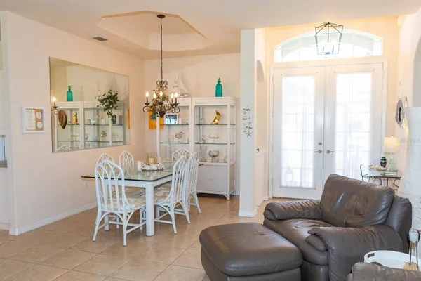a dining room with furniture a chandelier and window