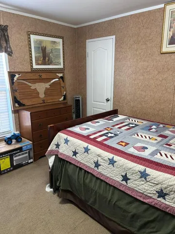 a bedroom with a bed and a lamp on dresser