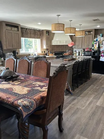 a kitchen with granite countertop a stove a sink a dining table and chairs