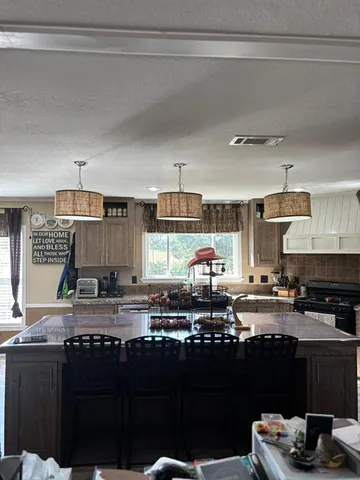 a kitchen with granite countertop a stove a sink and a cabinets