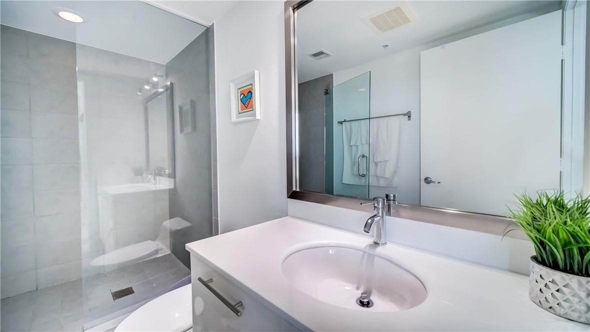92 Southwest 3rd Street, Unit 1606 Miami, FL 33130 - Photo 16 of 62 a bathroom with a sink and a mirror
