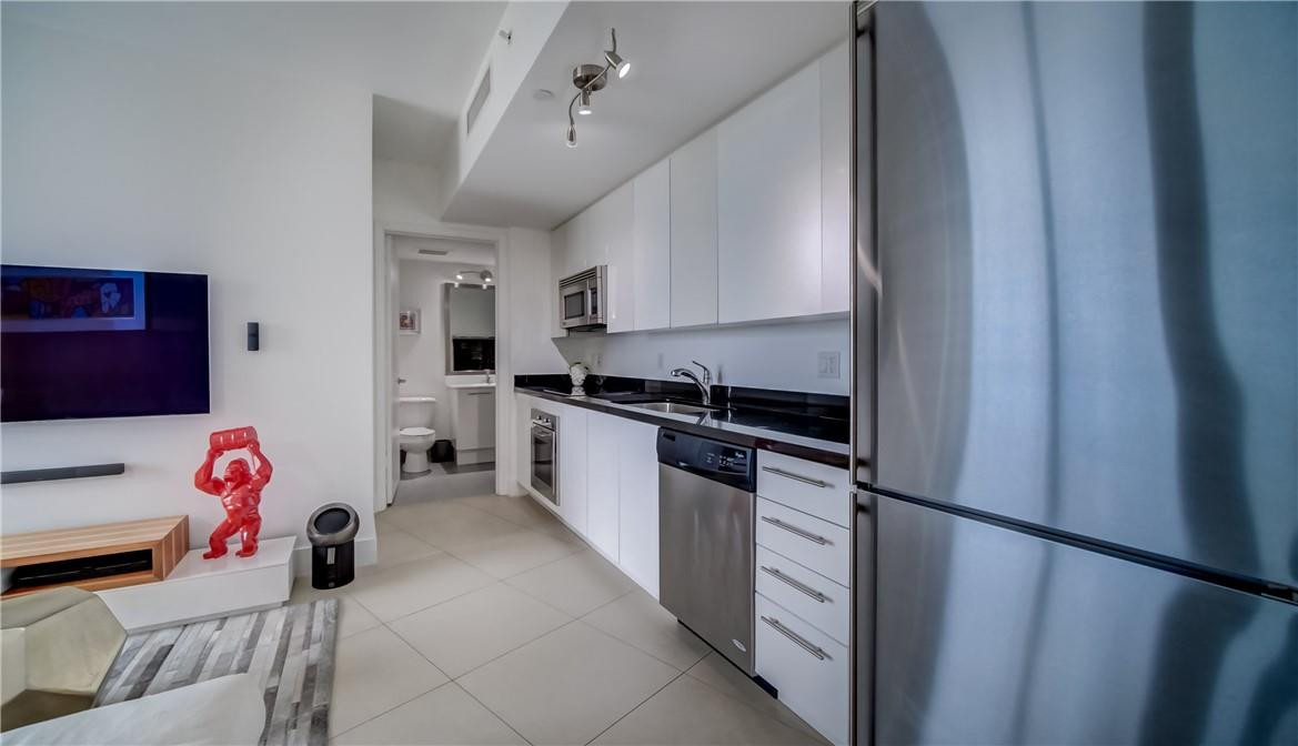 92 Southwest 3rd Street, Unit 1606 Miami, FL 33130 - Photo 4 of 62 a kitchen with a refrigerator and a stove top oven