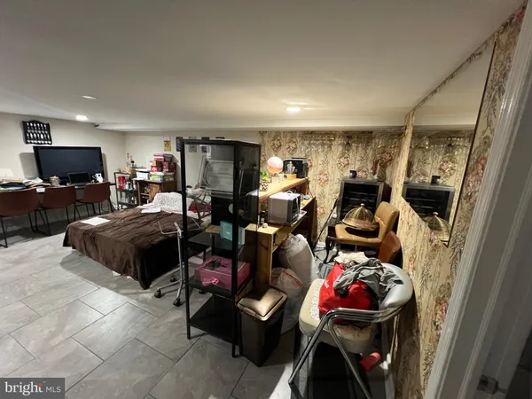 a living room with furniture a flat screen tv and gym equipment