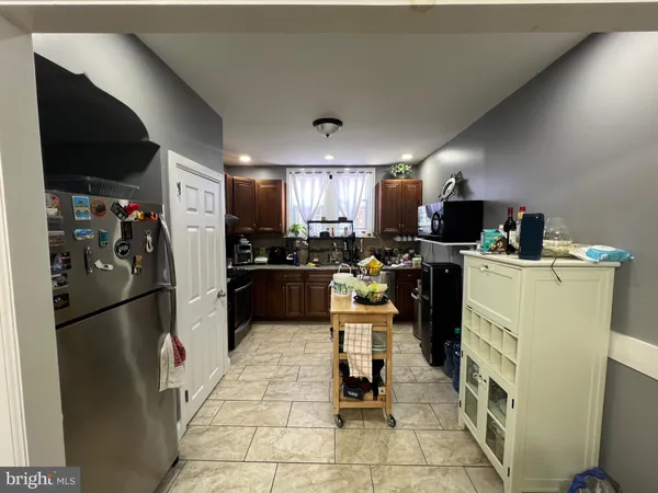 a kitchen with refrigerator a microwave and chairs