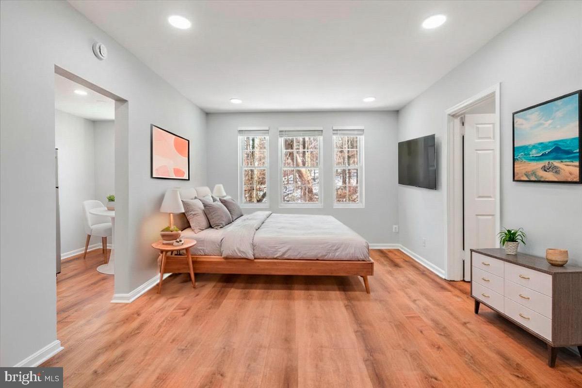 a spacious bedroom with a bed and a flat screen tv