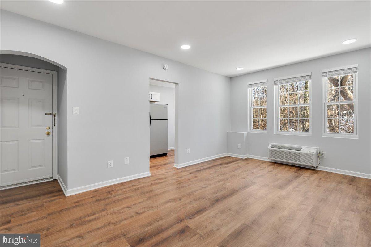 1909 North Rhodes Street, Unit 25 Arlington, VA 22201 - Photo 20 of 30 an empty room with wooden floor and windows