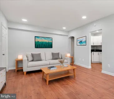 a living room with furniture and a wooden floor