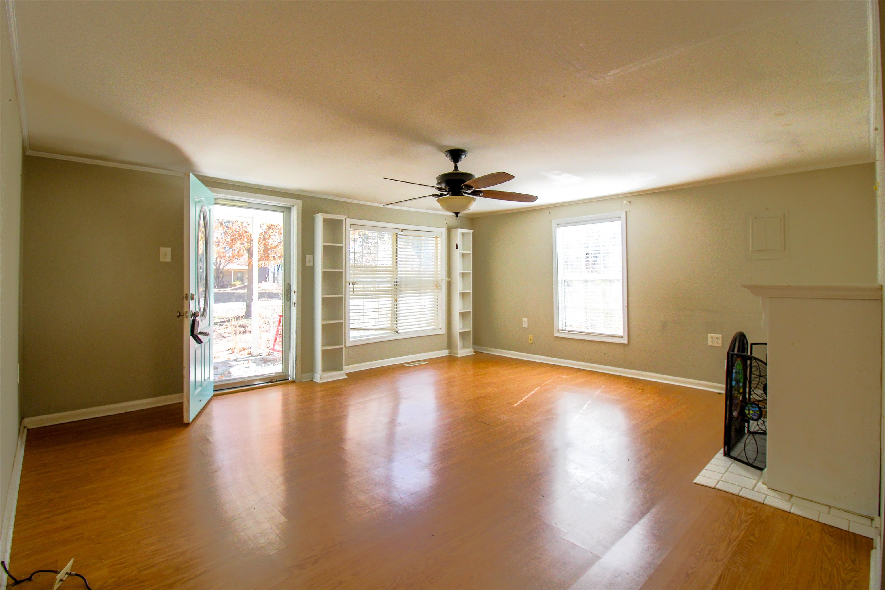 143 Marys Chapel Road Ripley, TN 38063 - Photo 2 of 23 Living room featuring light wood-style flooring, ornamental molding, ceiling fan, built ins and fireplace.