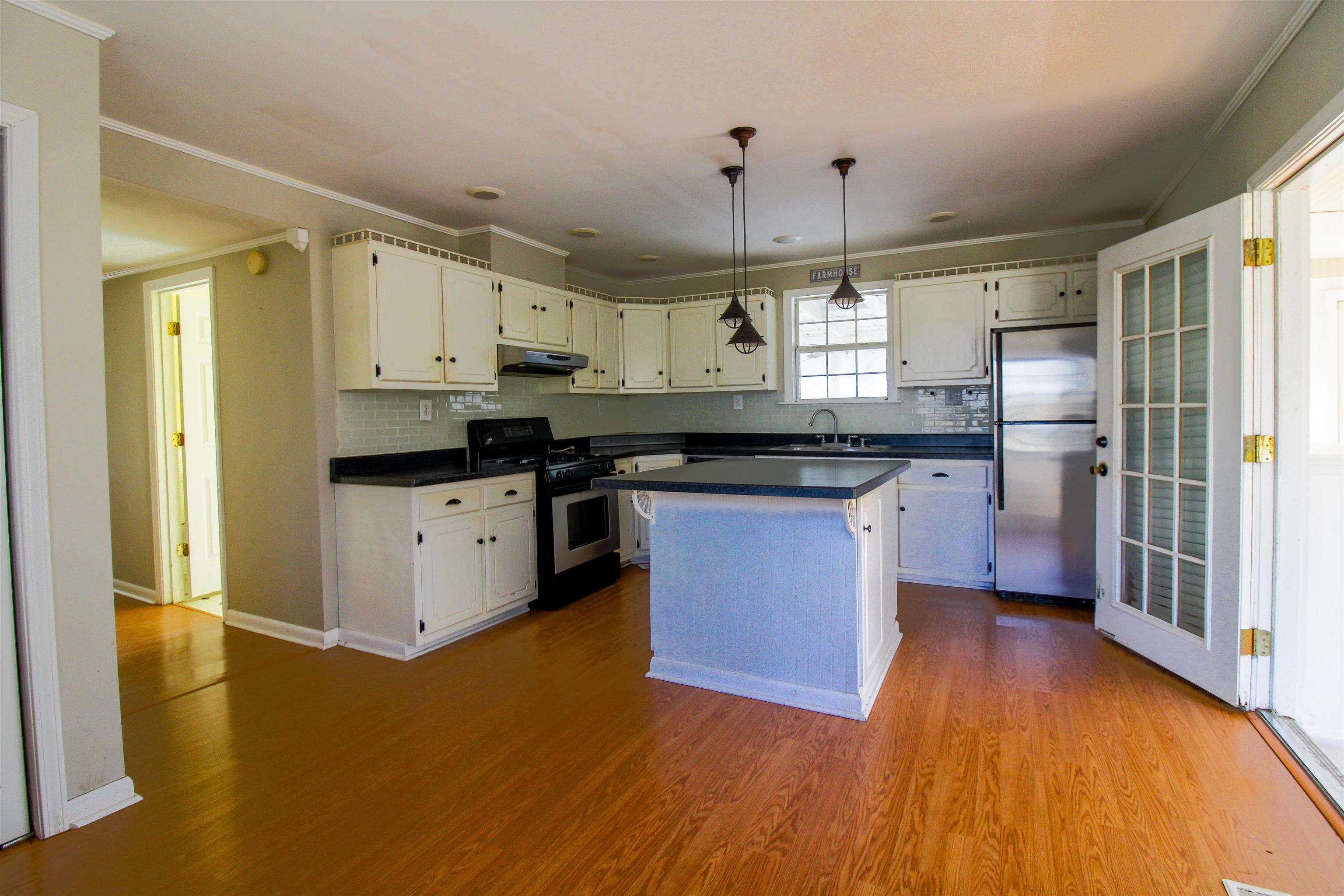 143 Marys Chapel Road Ripley, TN 38063 - Photo 6 of 23 Kitchen with dark countertops, pendant lighting, stainless steel appliances, ornamental molding, and dark wood-type flooring