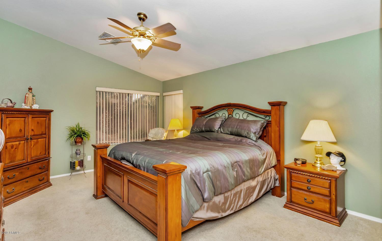 3488 South Ambush Pass Road Gilbert, AZ 85297 - Photo 8 of 19 a bedroom with a bed and a chandelier