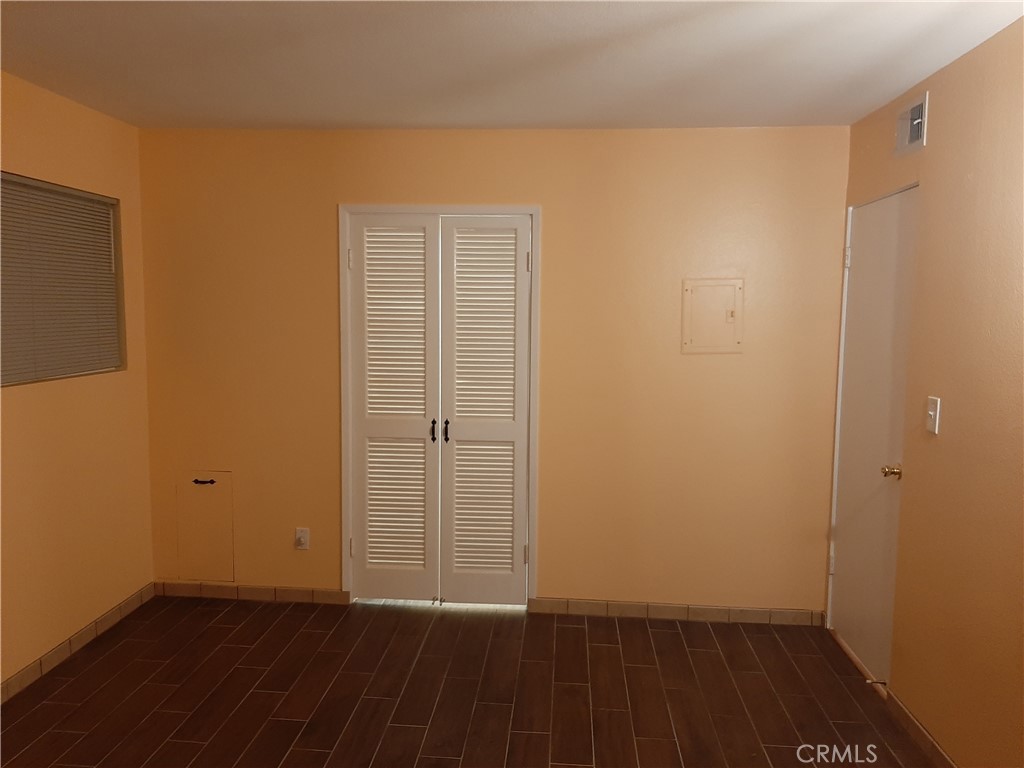 12592 Montecito Road, Unit 9 Seal Beach, CA 90740 - Photo 10 of 16 a view of an empty room with wooden floor and a window