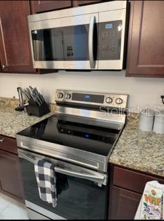 8836 Indigo Trail Loop Riverview, FL 33578 - Photo 3 of 11 a kitchen with a stove and a microwave