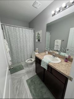 8836 Indigo Trail Loop Riverview, FL 33578 - Photo 8 of 11 a bathroom with a granite countertop sink a toilet a mirror and shower