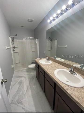 8836 Indigo Trail Loop Riverview, FL 33578 - Photo 10 of 11 a bathroom with a granite countertop double vanity sink and a mirror