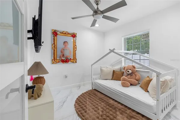 a large bedroom with a bed and a flat screen tv