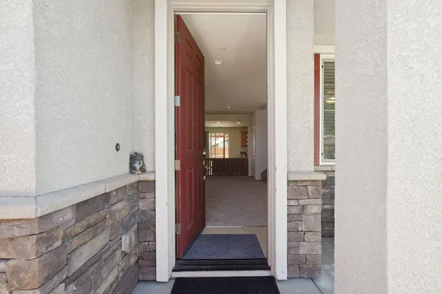 a view of a hallway with wooden floor and a living room