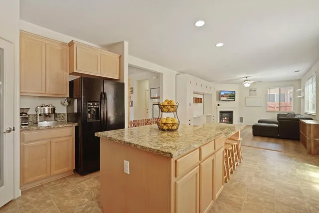 a kitchen with stainless steel appliances granite countertop a sink refrigerator and cabinets