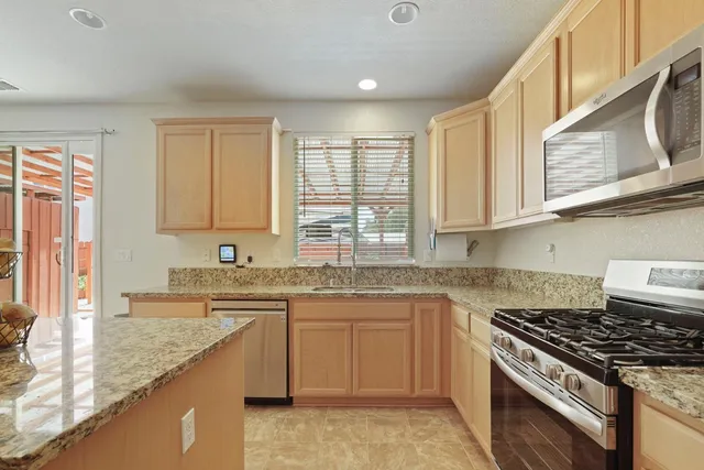 a kitchen with stainless steel appliances granite countertop a sink stove and cabinets