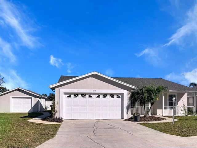 a view of a house with a yard and garage