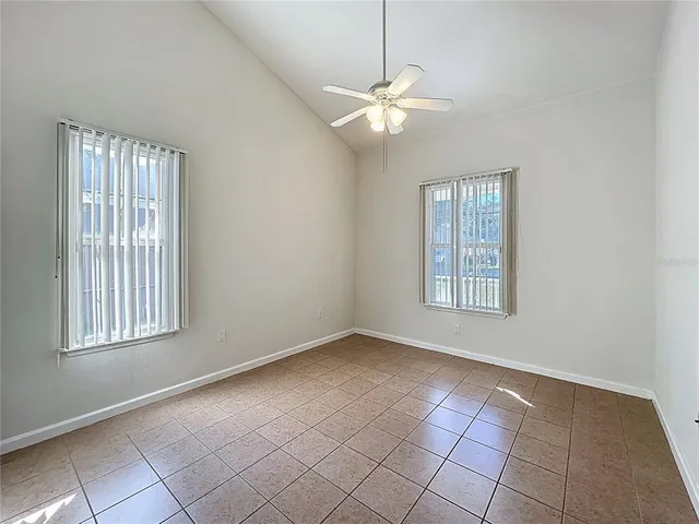 an empty room with fan and windows