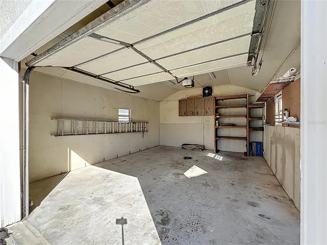 a view of a white house with a big yard and large tree