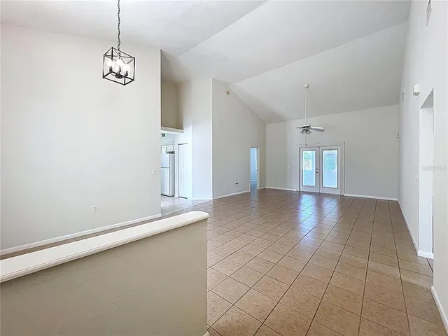 a view of a livingroom with a chandelier fan and windows