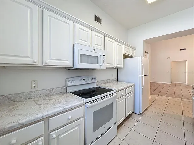 a kitchen with a refrigerator sink and cabinets