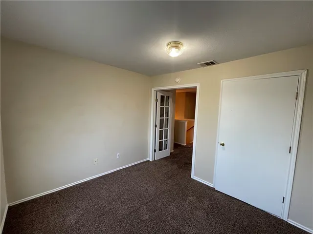 an empty room with closet and wooden floor