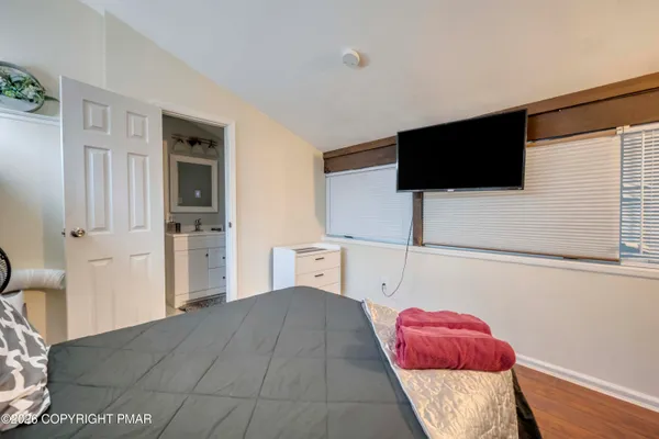 a bedroom with a bed and wooden floor