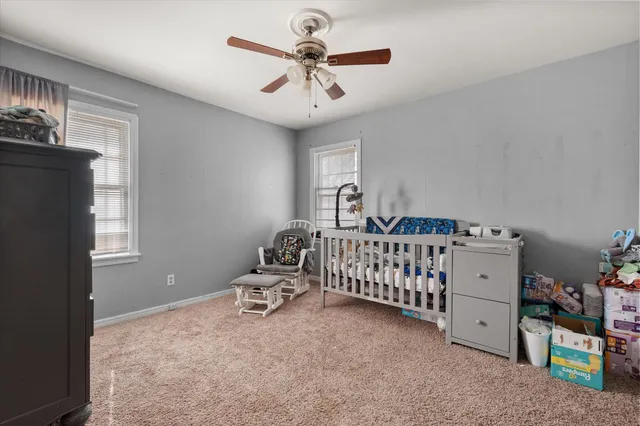 a spacious bedroom with a bed and a chandelier