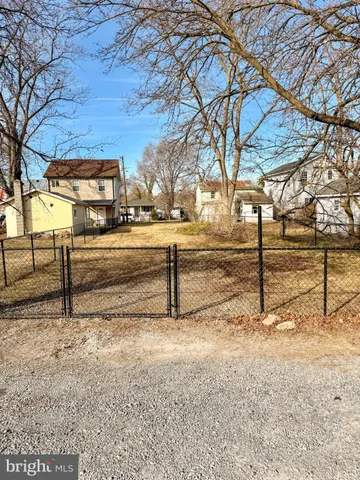 a view of a yard with wooden fence