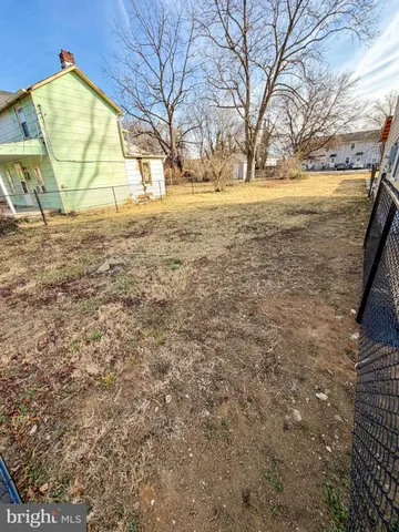 a view of an empty room with a small yard and wooden fence
