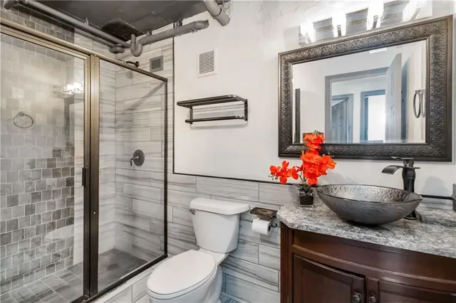 a bathroom with a granite countertop sink mirror vanity and toilet