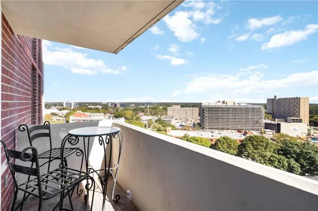 a view of a chairs and table in front of building