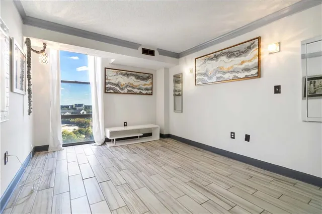 a view of an empty room with wooden floor