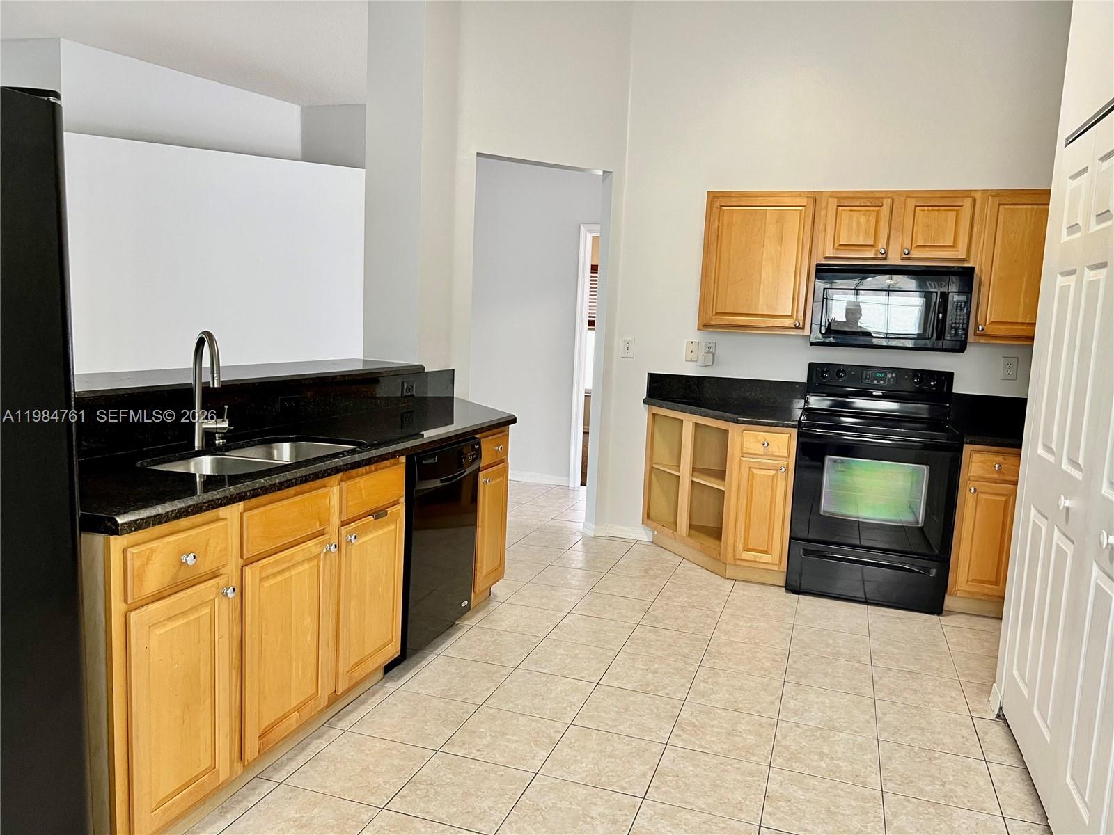 11854 Southwest 8th Street Pembroke Pines, FL 33025 - Photo 5 of 11 a kitchen with stainless steel appliances granite countertop a stove a sink and a microwave