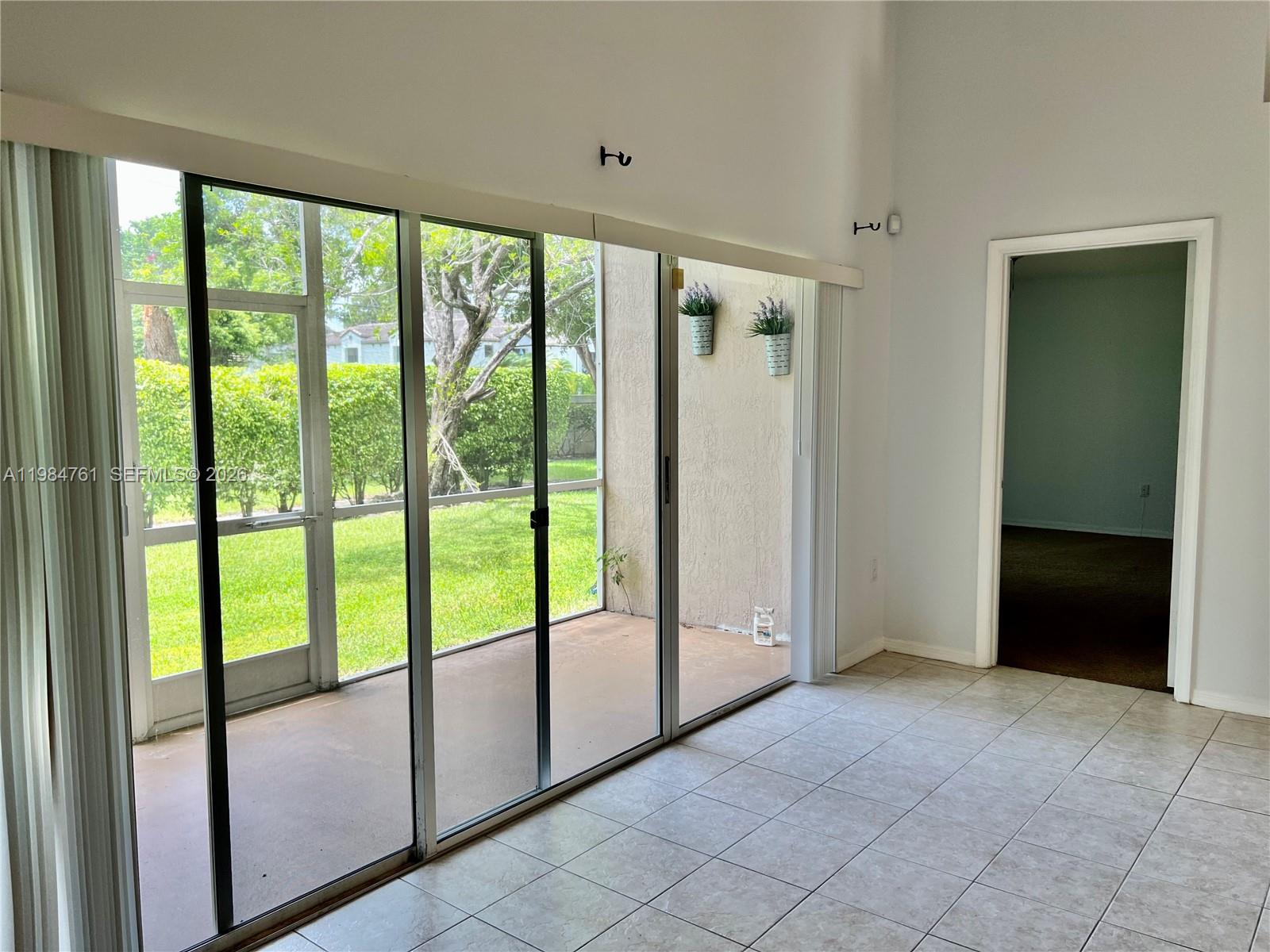 11854 Southwest 8th Street Pembroke Pines, FL 33025 - Photo 10 of 11 a view of an empty room with sliding glass door