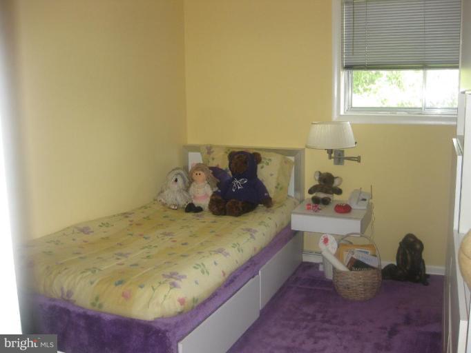 2418 Forest Green Road Baltimore, MD 21209 - Photo 9 of 12 a bed sitting in a bedroom next to a window