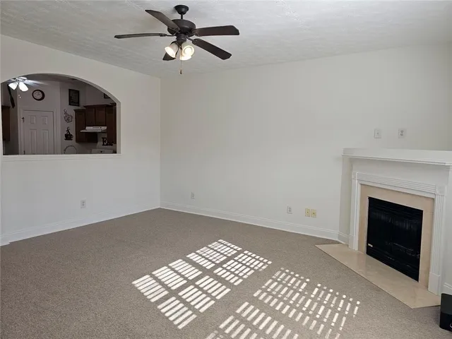 a view of empty room with fireplace and fan